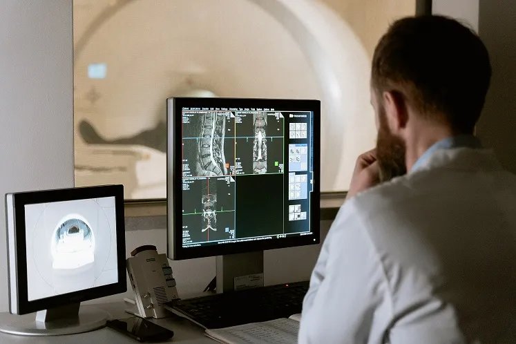 man is examining the MRI screen